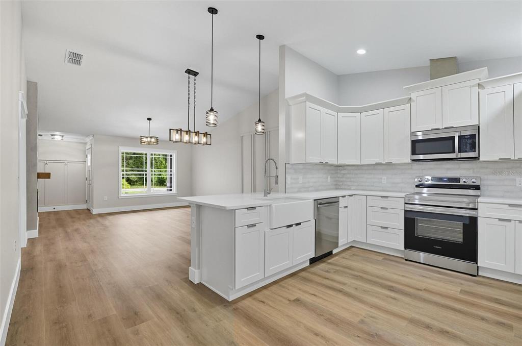 13 Fanshawe Lane Palm Coast, FL 32137 - Photo 13 of 60 a kitchen with stainless steel appliances granite countertop a stove a sink and a microwave