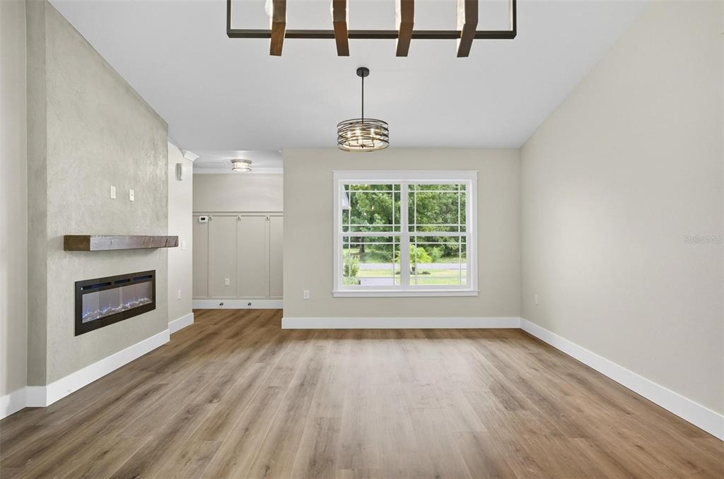 13 Fanshawe Lane Palm Coast, FL 32137 - Photo 8 of 60 an empty room with wooden floor a ceiling fan and windows
