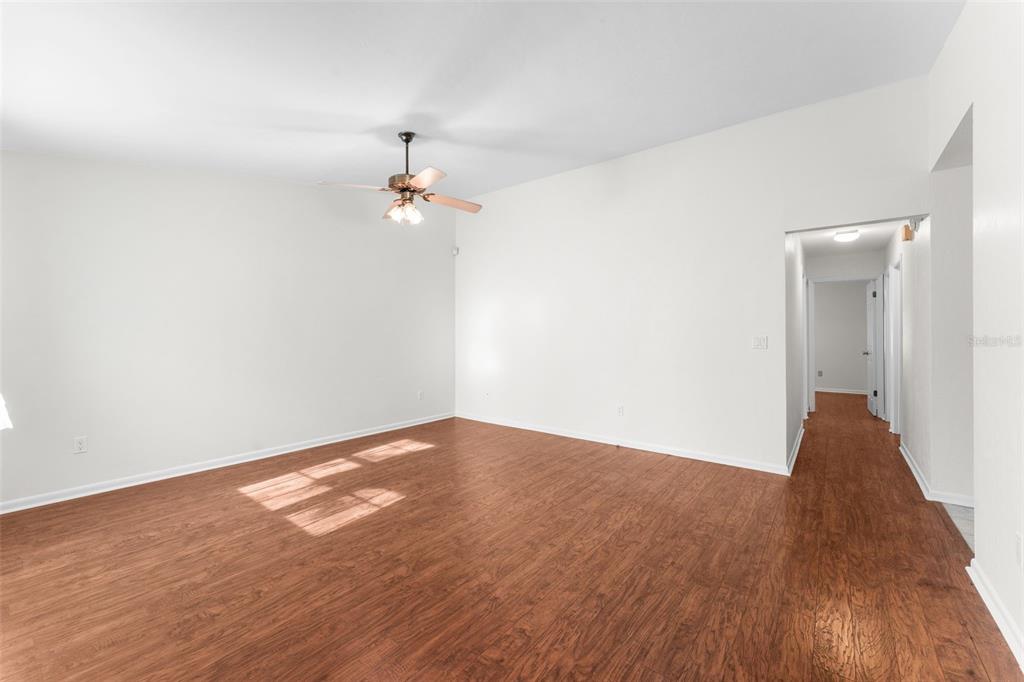 2026 Southwest 73rd Street Gainesville, FL 32607 - Photo 5 of 20 a view of a room with wooden floor and a ceiling fan