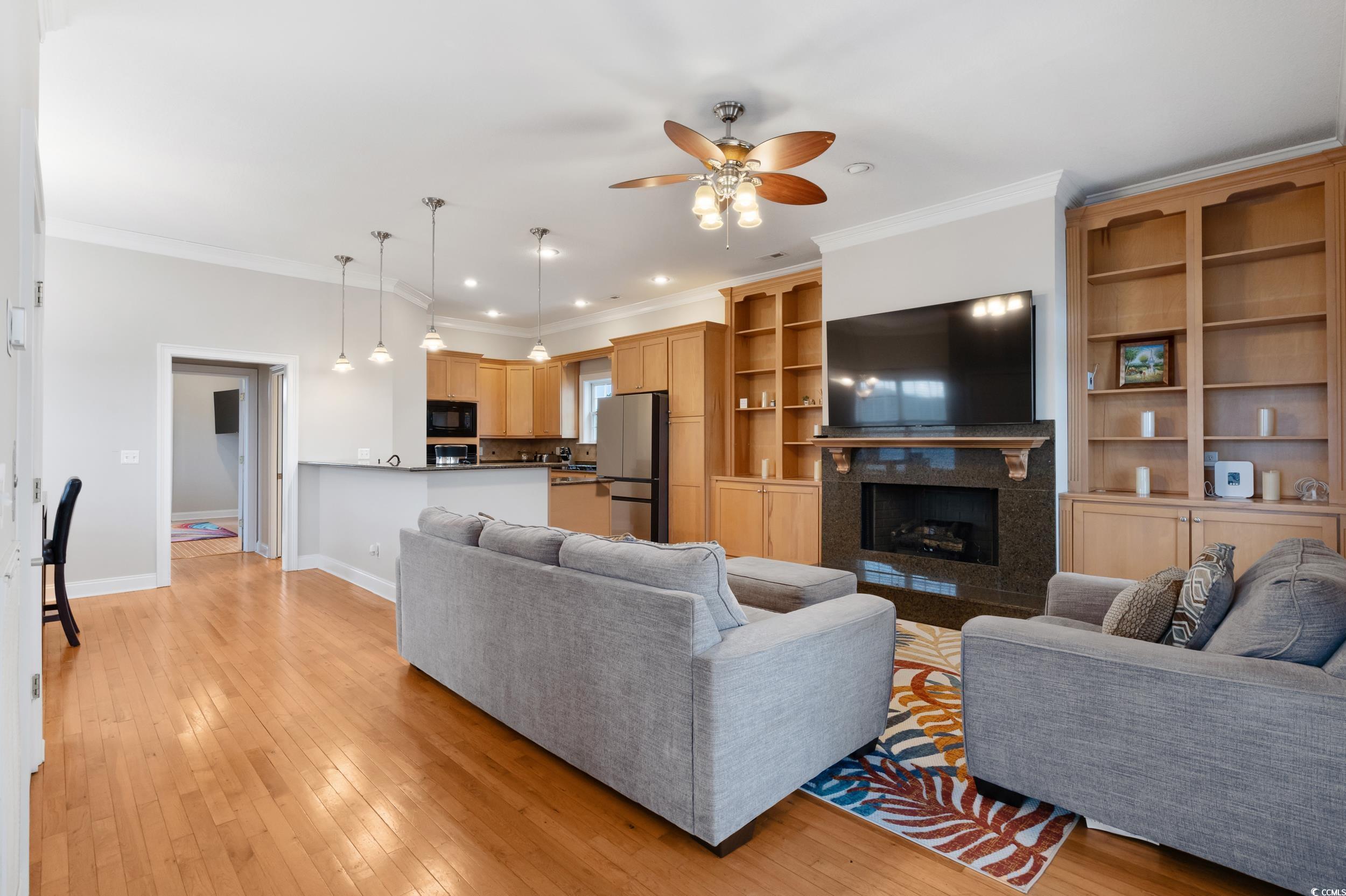 414 St.Julian Lane Myrtle Beach, SC 29579 - Photo 2 of 15 Living room featuring ornamental molding, ceiling fan, a tiled fireplace, light wood finished floors, and recessed lighting