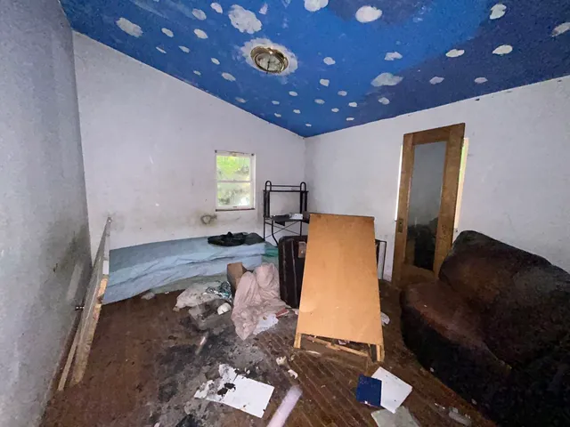 a bedroom with bed and wooden floor