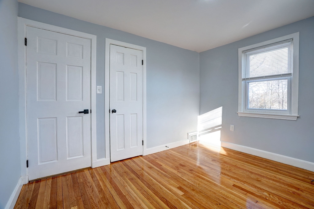 23 Langley Circle, Unit 1 Quincy, MA 02170 - Photo 13 of 27 a view of empty room with wooden floor and fan