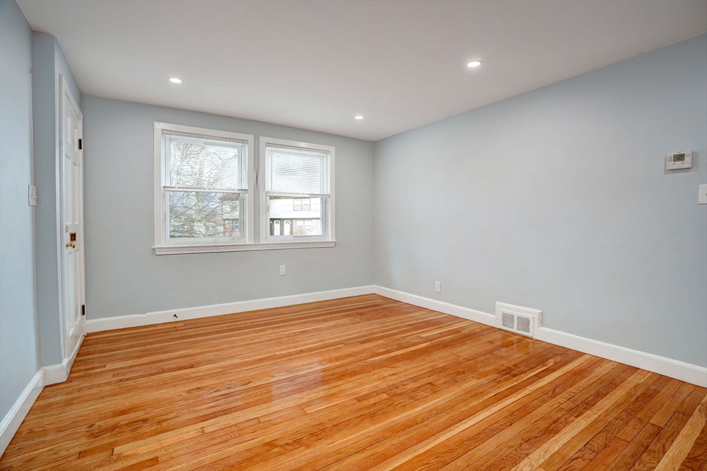23 Langley Circle, Unit 1 Quincy, MA 02170 - Photo 8 of 27 a view of an empty room with wooden floor and a window