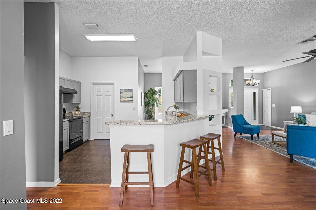 2030 Weber Road Malabar, FL 32950 - Photo 12 of 41 a kitchen with stainless steel appliances granite countertop a dining table chairs refrigerator and sink