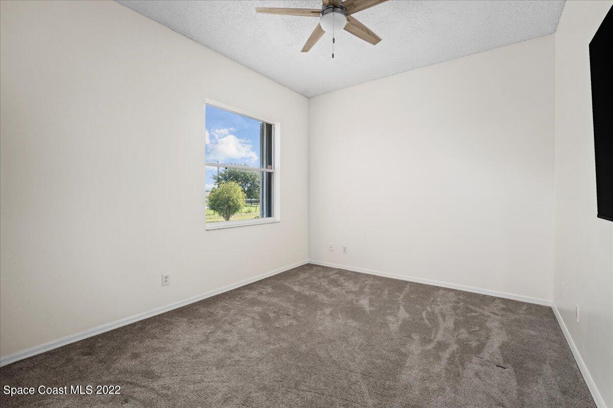 2030 Weber Road Malabar, FL 32950 - Photo 19 of 41 an empty room with a window and a ceiling fan