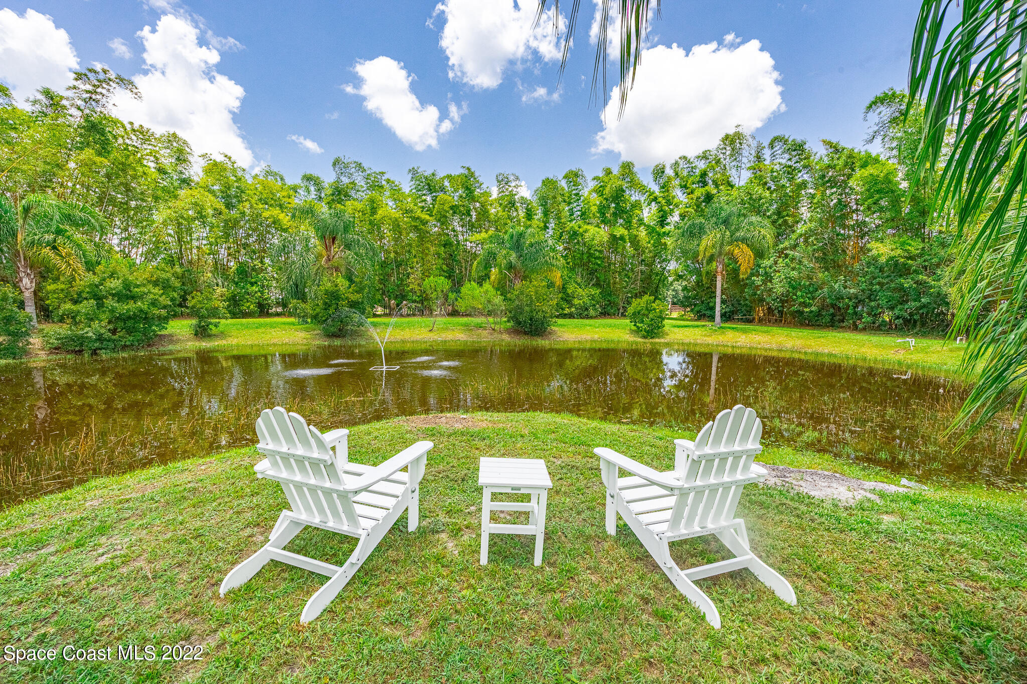 2030 Weber Road Malabar, FL 32950 - Photo 29 of 41 a view of a lake with table and chairs under an umbrella