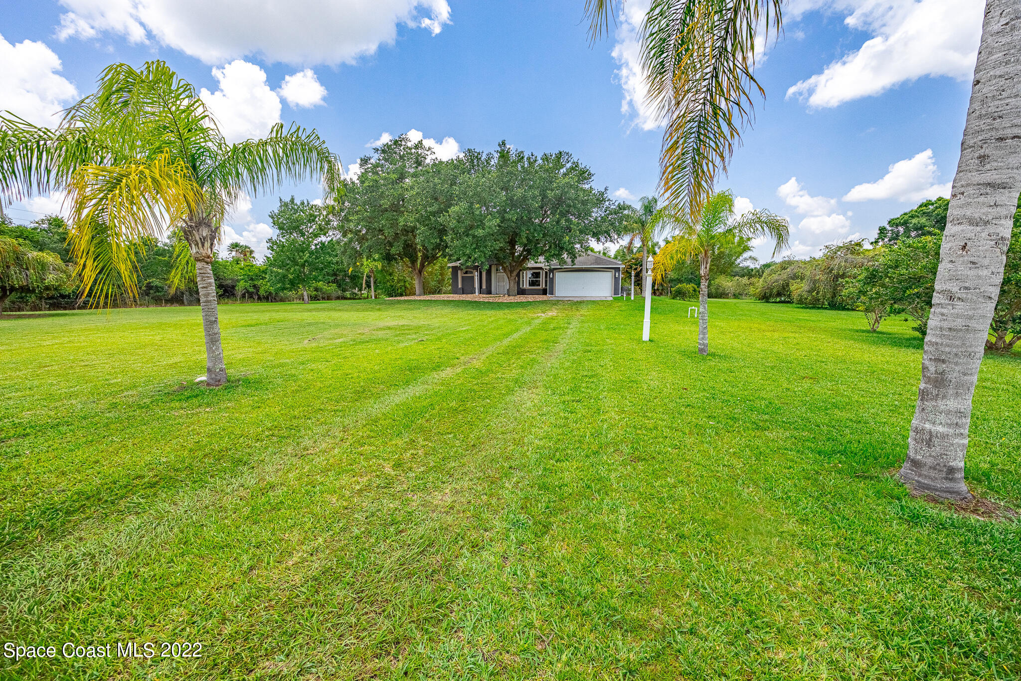 2030 Weber Road Malabar, FL 32950 - Photo 32 of 41 a backyard of a house with palm trees
