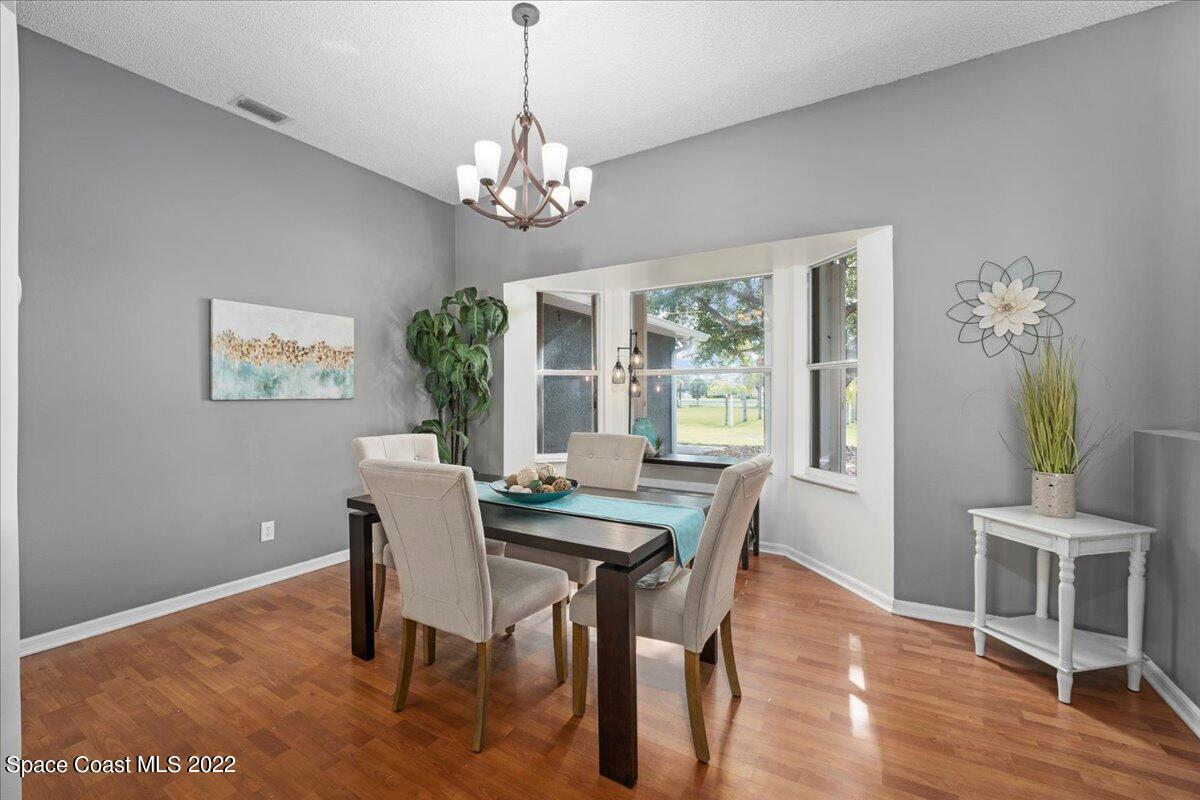 2030 Weber Road Malabar, FL 32950 - Photo 7 of 41 a view of a dining room with furniture a chandelier and wooden floor
