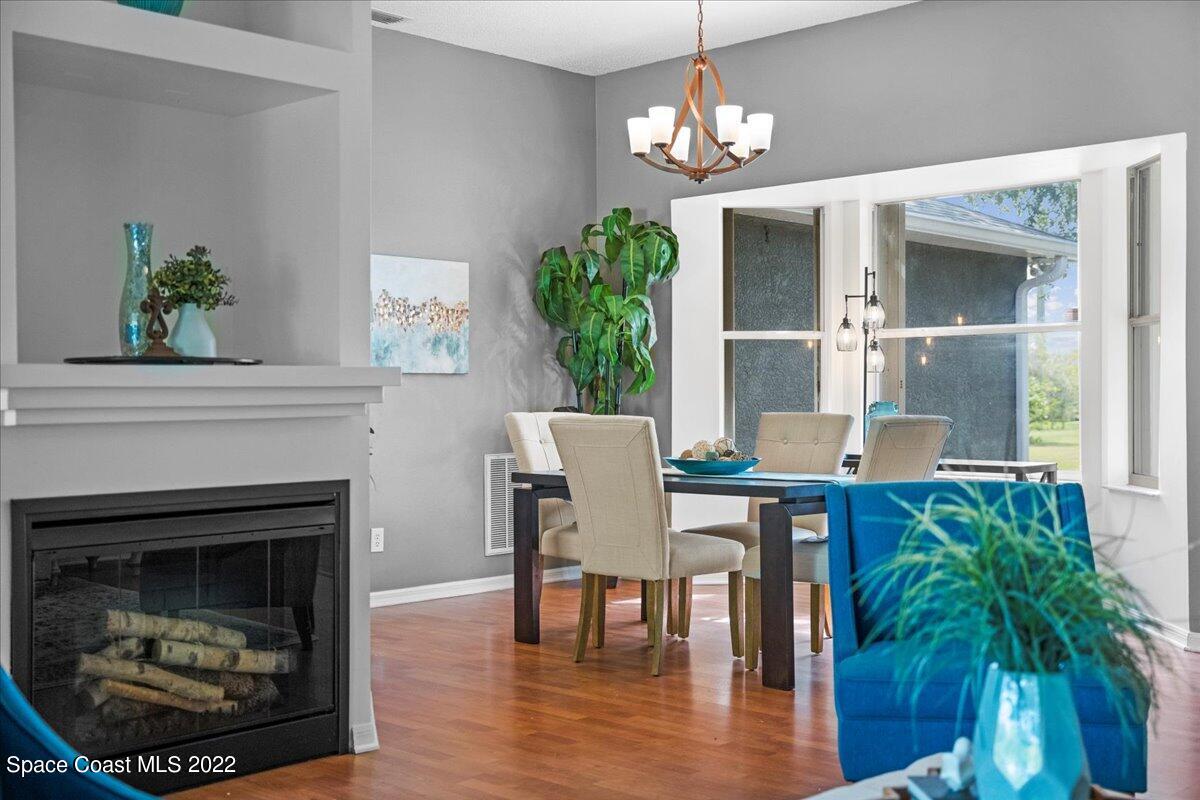 2030 Weber Road Malabar, FL 32950 - Photo 8 of 41 a view of a dining room with furniture wooden floor and a fireplace