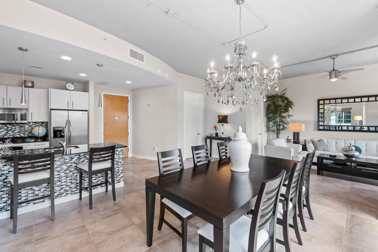 335 Southeast 6th Avenue, Unit 304 Delray Beach, FL 33483 - Photo 19 of 37 a view of a dining room with furniture and chandelier