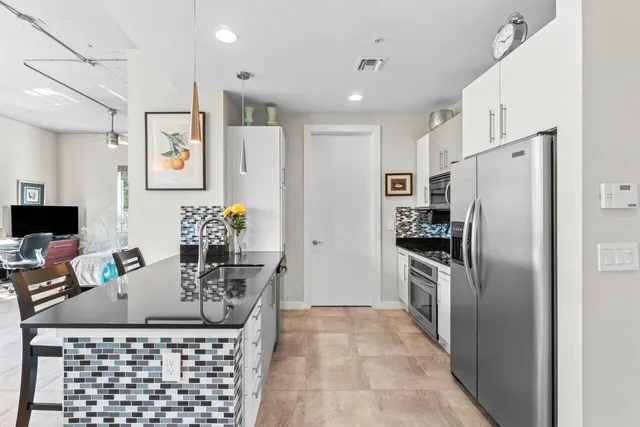 a kitchen with stainless steel appliances granite countertop a refrigerator and a stove top oven