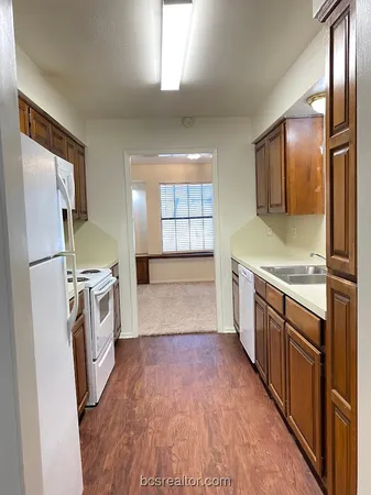 a view of a kitchen with a sink and refrigerator