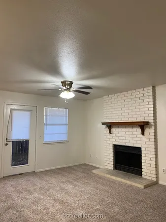 an empty room with windows and fireplace