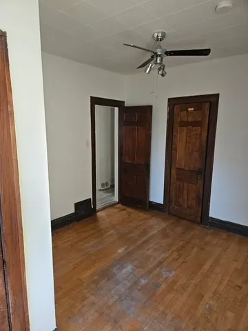 an empty room with closet and fan