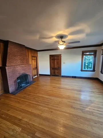 a view of a livingroom with wooden floor and a fireplace