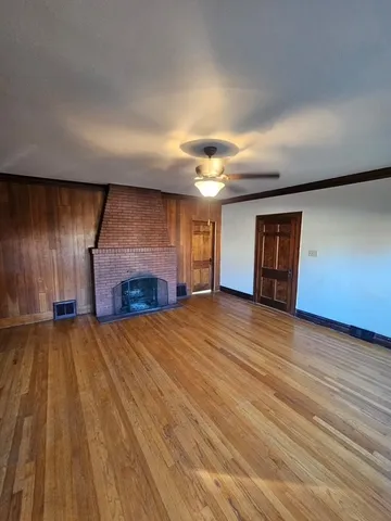 an empty room with wooden floor and fireplace