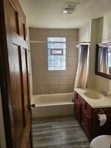 a bathroom with a tub sink and mirror