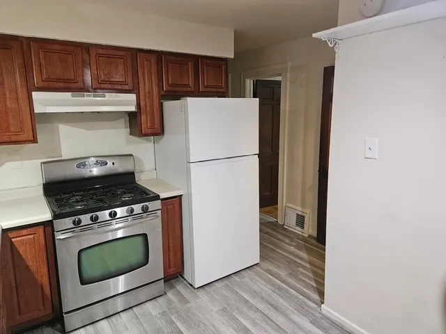 a kitchen with a stove top oven and refrigerator