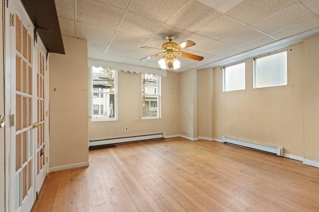 68 Murdock Street Boston, MA 02135 - Photo 12 of 35 an empty room with wooden floor chandelier and windows