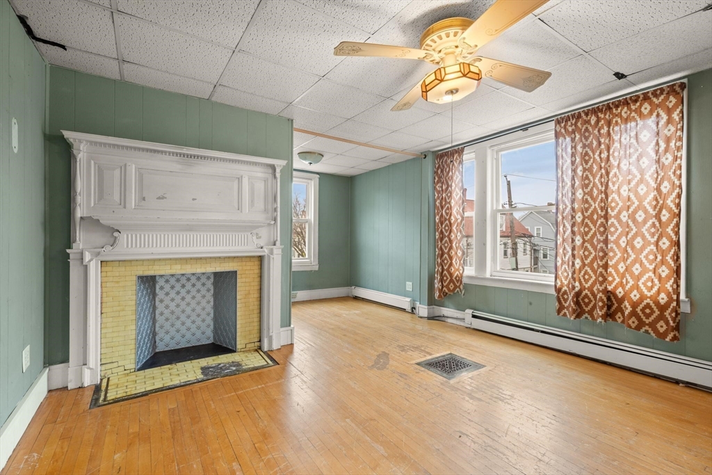 68 Murdock Street Boston, MA 02135 - Photo 19 of 35 a view of an empty room with chandelier fan and fire place