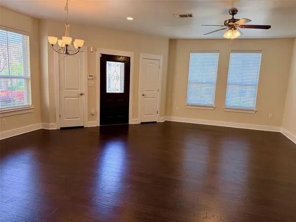 a view of a livingroom with wooden floor and a ceiling fan