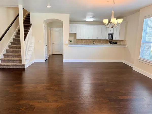 a view of a kitchen with wooden floor and chandelier