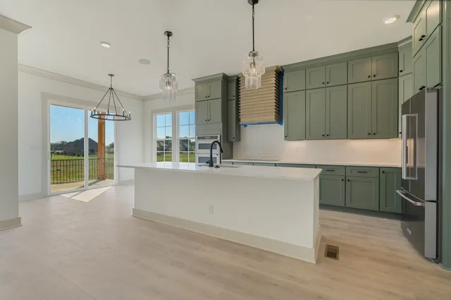 a kitchen with kitchen island a counter top space appliances and a counter top space