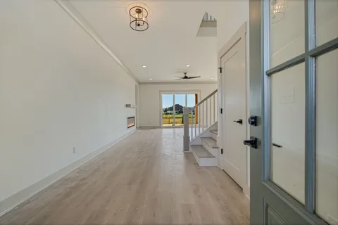 a view of a hallway with wooden floor and a bathroom