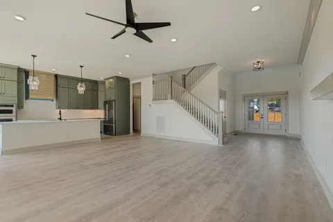 a view of an empty room with a window and a kitchen view