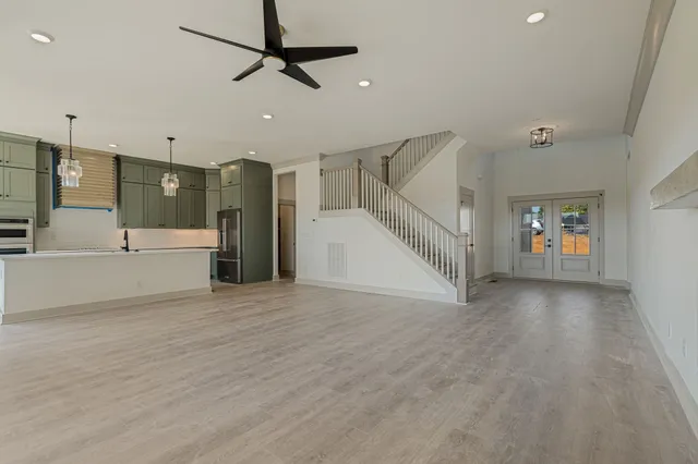 a view of an empty room with a window and a kitchen view