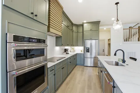 a kitchen with kitchen island a sink stove and refrigerator