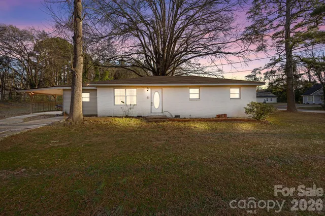 a front view of house with yard and trees around