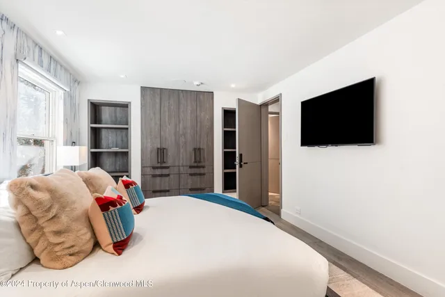 a bedroom with a bed and flat screen tv