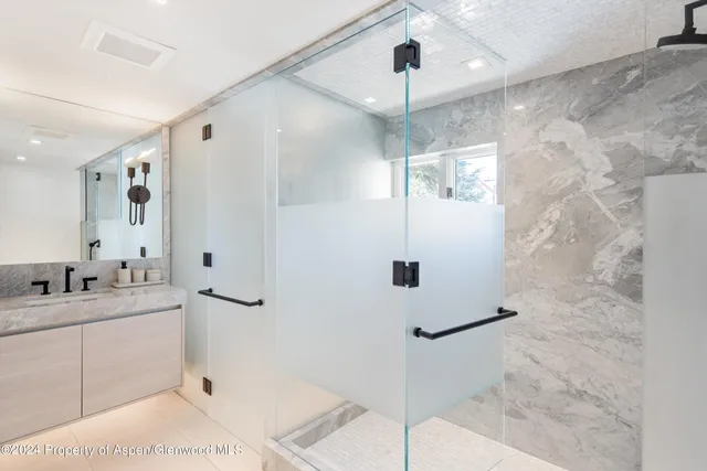 a bathroom with a double vanity sink mirror and shower