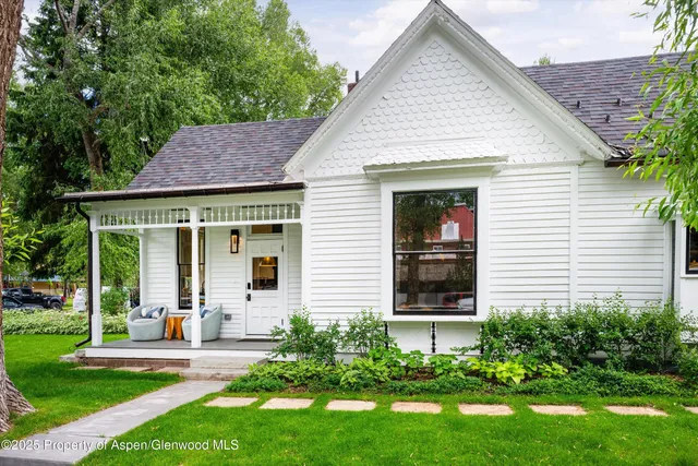 a front view of a house with a yard and potted plants