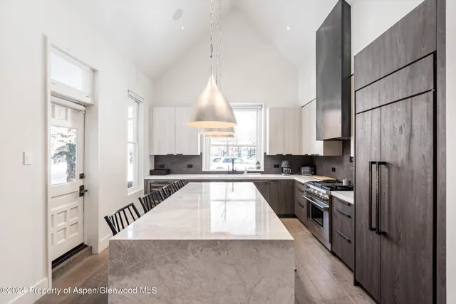 a large kitchen with cabinets a sink and stainless steel appliances
