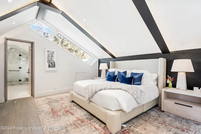 a bedroom with a large bed and a large mirror on the dresser