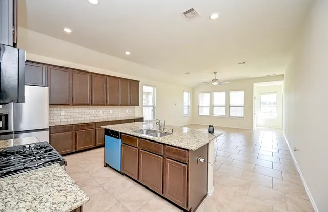 a kitchen with stainless steel appliances granite countertop a sink stove and cabinets