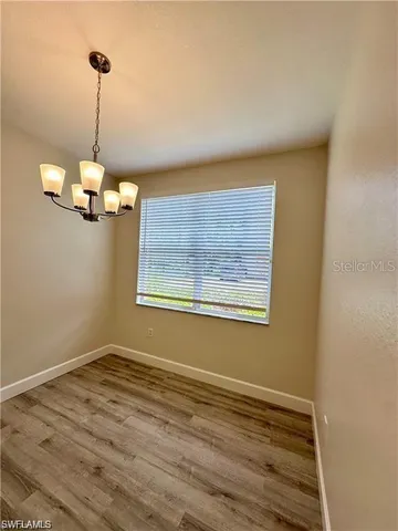 a view of a room with window wooden floor and chandelier