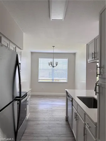 a kitchen with stainless steel appliances a sink cabinets and a wooden floor