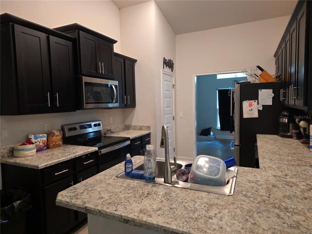 9 Cedar Run Ocala, FL 34472 - Photo 3 of 15 a kitchen with granite countertop a sink dishwasher stove and cabinets