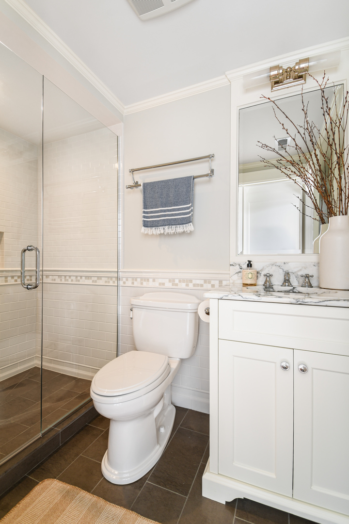 3751 North Greenview Avenue Chicago, IL 60613 - Photo 38 of 52 a bathroom with a granite countertop toilet sink and a mirror