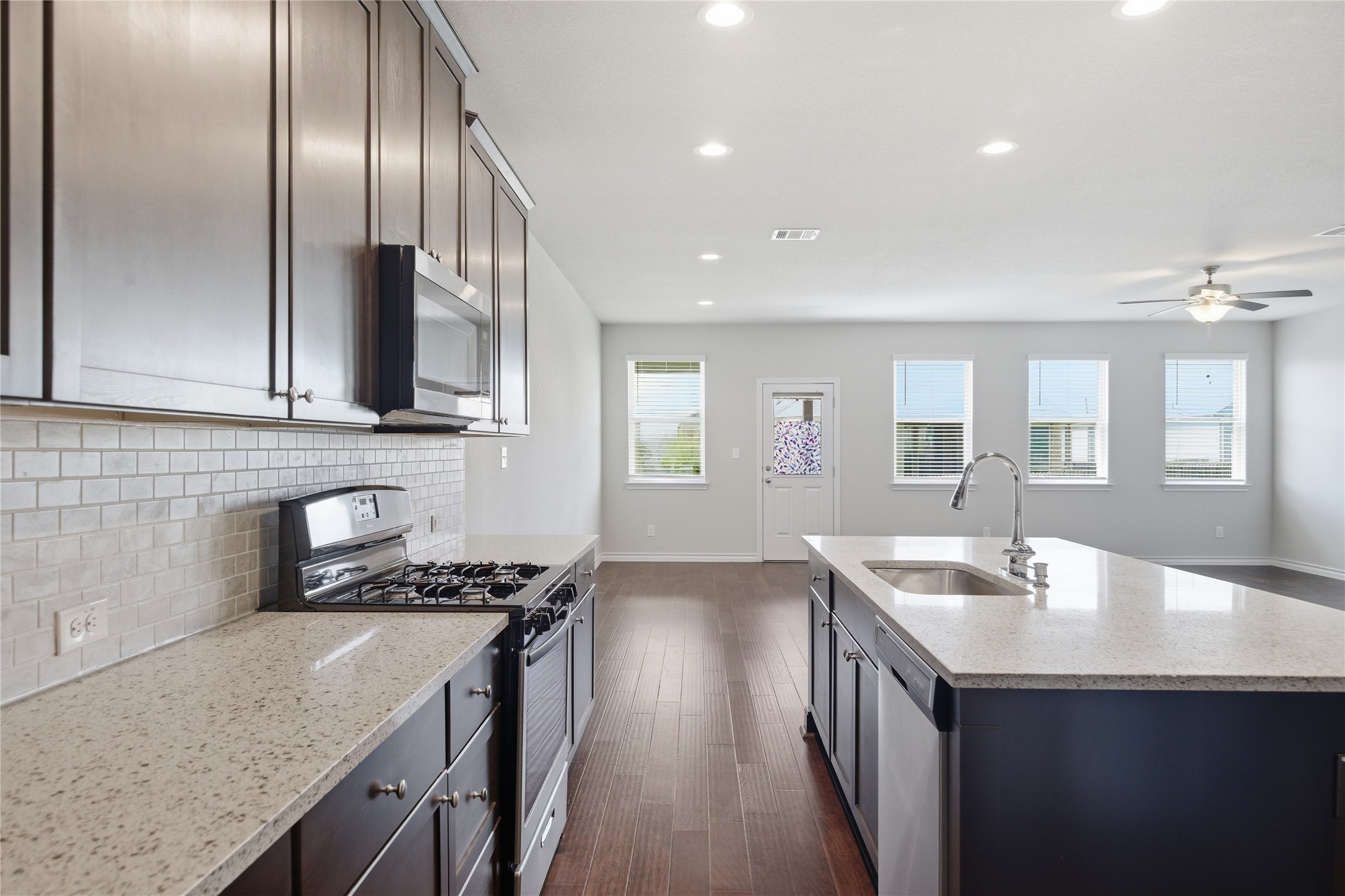 6764 Catania Loop Round Rock, TX 78665 - Photo 13 of 33 a kitchen with granite countertop stainless steel appliances a sink stove top oven and cabinets