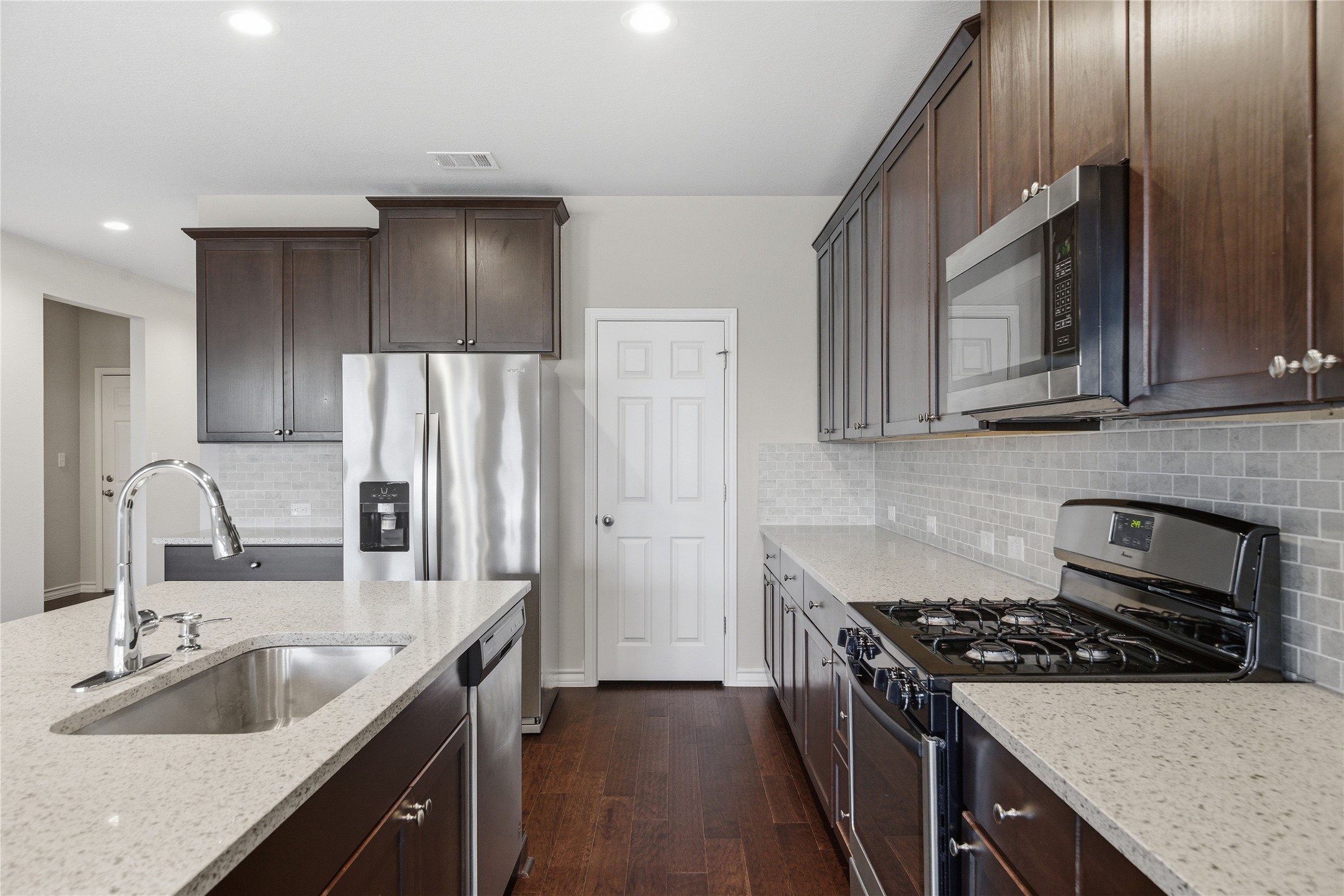 6764 Catania Loop Round Rock, TX 78665 - Photo 14 of 33 a kitchen with stainless steel appliances granite countertop a sink stove and refrigerator