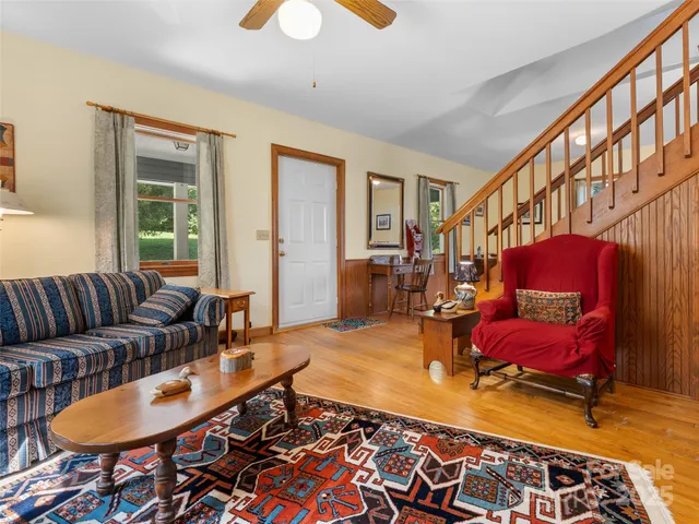 a living room with furniture a rug and a window