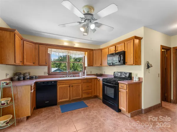 a kitchen with stainless steel appliances granite countertop wooden cabinets a sink a stove a refrigerator and island