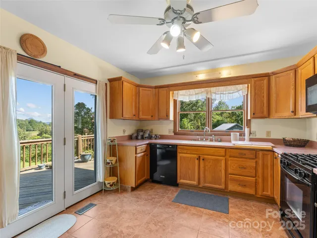 a kitchen with stainless steel appliances granite countertop a stove and a view of living room