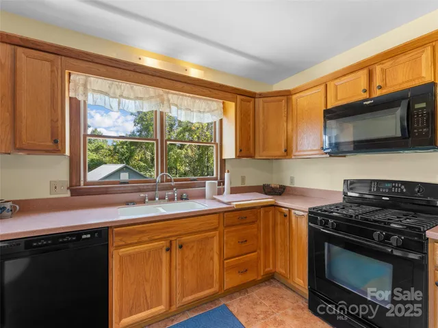 a kitchen with stainless steel appliances a stove sink and microwave