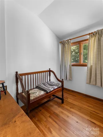 a view of a room with wooden floor and a window