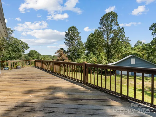 a view of a balcony with wooden floor & fence